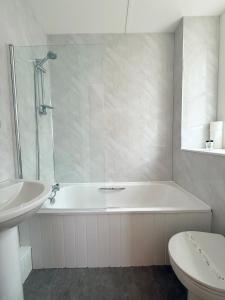 a bathroom with a tub and a toilet and a sink at The Western in St Ives