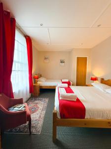 a hotel room with two beds and a chair at The Western in St Ives