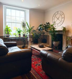 a living room with couches and a fireplace with plants at The Western in St Ives