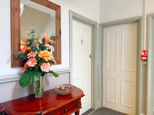 a vase of flowers on a table next to a mirror at The Western in St Ives