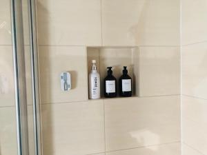 two bottles of wine are sitting on a shelf in a shower at Ferienwohnung Jung in Zülpich +21 photos