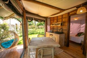 a dining room with a table and a bedroom at Procida Camp & Resort - La Caravella in Procida