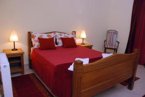a bedroom with a bed with red sheets and two lamps at Kuca Veljovica in Belgrade