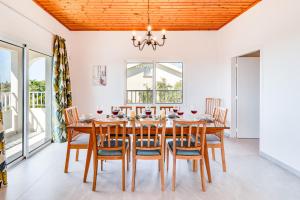 ein Esszimmer mit einem Holztisch und Stühlen in der Unterkunft Villa Bettina By Ezoria Villas in Coral Bay + 21 Fotos