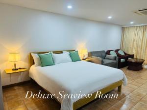 a bedroom with a large white bed and a couch at Surin Bay Inn in Surin Beach +37 photos