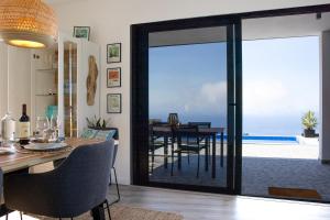 ein Esszimmer mit Blick auf das Meer in der Unterkunft Vila Rouxinol in Arco da Calheta