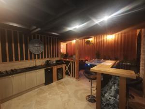 a kitchen with wooden walls and a clock on the wall at love room paradix in Saint-Denis-de-Pile
