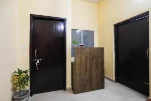 two black doors in a room with a plant at Hotel O Laavin Inn Near Gomti Riverfront Park in Lucknow