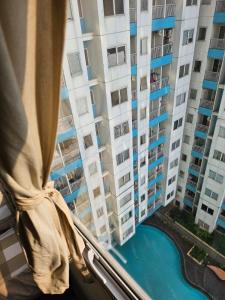 Blick aus einem Fenster auf ein großes Wohnhaus in der Unterkunft Apartemen The Nest in South Tangerang
