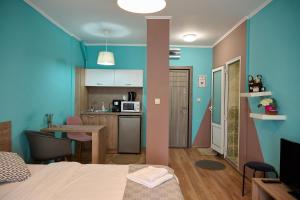 a room with a bed and a kitchen with blue walls at Center in Shumen