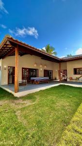 una casa con patio y patio de césped en Casa Morena Luz na Vila de Cumuru, pra fazer tudo a pé! 350m da Praia do Pier!, en Cumuruxatiba