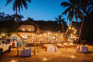 a restaurant with tables and chairs and lights at night at Ursula Beach Resort in El Nido