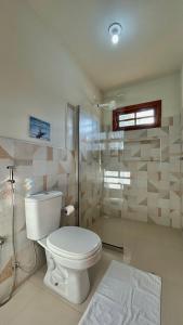 Un baño con inodoro y ducha de cristal. en Casa Morena Luz na Vila de Cumuru, pra fazer tudo a pé! 350m da Praia do Pier!, en Cumuruxatiba