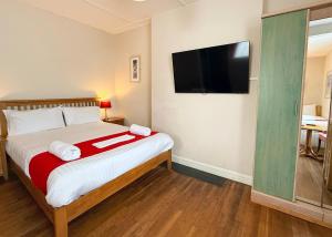 a bedroom with a bed with a flat screen tv at The Western in St Ives