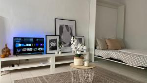 - un salon blanc avec une télévision et un lit dans l'établissement Studio Terrasse Vue Mer Saint-Raphaël - Plages, Ville et Gare à Pied, à Saint-Raphaël 43 autres photos