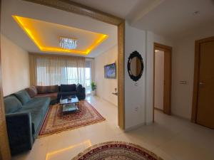 uma sala de estar com um sofá e uma mesa em Appart en bord de mer avec piscine vue imprenable em Aourir