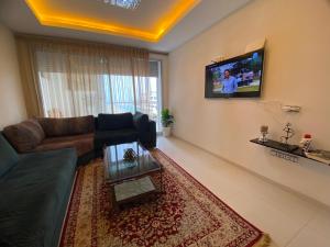 アウリールにあるAppart en bord de mer avec piscine vue imprenableのリビングルーム(ソファ、壁掛けテレビ付)