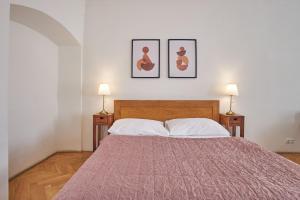 a bedroom with a bed with two lamps on two tables at Charles Bridge Apartments in Prague