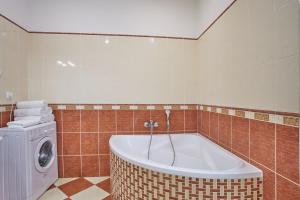 a bathroom with a tub and a washing machine at Charles Bridge Apartments in Prague