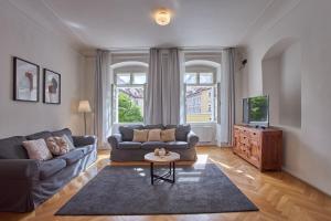 a living room with a couch and a tv at Charles Bridge Apartments in Prague