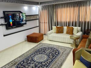 a living room with a couch and a tv at Appartement RITZ in Tangier