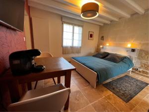 a bedroom with a bed and a table and a desk at La Petite Gendronnière in Fresnes +16 photos