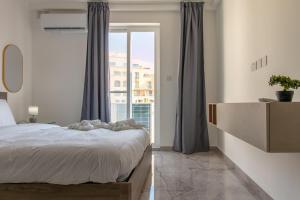 a bedroom with a bed and a large window at Spinola Seafront Deluxe in St. Julianʼs