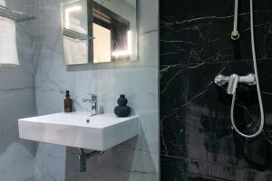 a bathroom with a white sink and a shower at Spinola Seafront Deluxe in St. Julianʼs +16 photos