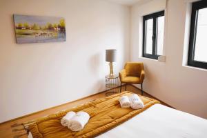 een slaapkamer met een bed en een stoel met handdoeken bij Francos Family House in Porto