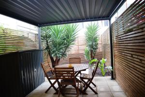 een patio met een tafel en stoelen en een palmboom bij Francos Family House in Porto