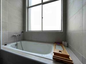 a bathroom with a bath tub with a window at GioiaHome with 6 bedroom and 15 guest in Taiping +32 photos