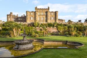 a large castle with a fountain in front of it at Clocktower - Culzean Castle in Maybole