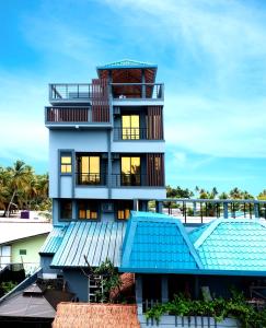 a tall building with a blue roof at Baa Sand Maldives in Kudarikilu