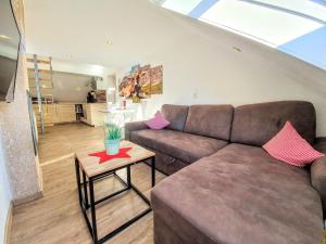 a living room with a brown couch and a table at Ferienwohnungen Wolf - Wohnung "Breitenberg" 2,5 Zimmer mit Bergblick in Pfronten +8 photos
