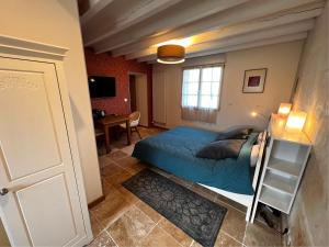 a small bedroom with a bed and a desk at La Petite Gendronnière in Fresnes