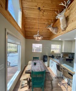 a kitchen with a wooden table with antlers on the ceiling at Riverbend Serenity Cabins in Pangburn