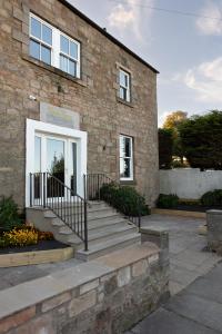 a brick building with stairs leading to a door at Rob Roy - Self Check-In Boutique Accommodation in Berwick-Upon-Tweed