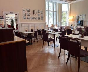a restaurant with tables and chairs in a room at Hotel Astrid am Kurfürstendamm in Berlin