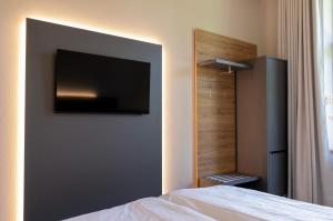 a bedroom with a flat screen tv on a wall at Gästehaus am Lausitzring in Poley