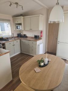 a kitchen with a wooden table in a room at Lytham Luxe 6 Birth Caravan in Weeton