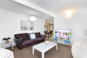 a living room with a couch and a tv at Sea View Hilltop Villa, Blouberg in Cape Town