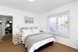 a white bedroom with a bed and a window at Sea View Hilltop Villa, Blouberg in Cape Town