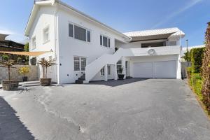 a white house with a large driveway at Sea View Hilltop Villa, Blouberg in Cape Town