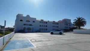 ein weißes Auto, das vor einem Gebäude geparkt ist in der Unterkunft Cozy Apartment in Sagres in Sagres