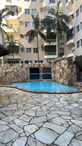a swimming pool in front of a building with palm trees at thermasparadise Rio quente in Rio Quente +10 photos