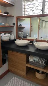 Un baño con dos lavabos y un espejo grande. en VILLA COCODY, en Sainte-Anne