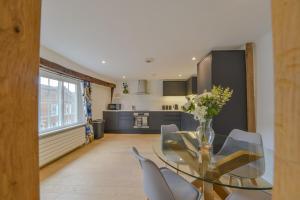 セント・オールバンズにあるLuxury Character Apartment St Albans By Central Stays Short Lets & Serviced Accommodation With Free Parkingのダイニングルーム(ガラスのテーブル、椅子付)