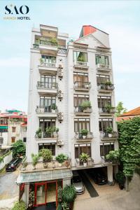 a white building with potted plants on it at Khách Sạn Sao in Hanoi