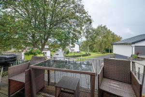 ein Balkon mit Glastisch und Stühlen in der Unterkunft Ferienhaus Störzel - Wohnung B in Hundheim