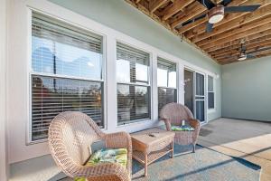 two chairs and a table on a porch with windows at Romar Lakes 104B in Orange Beach +48 photos